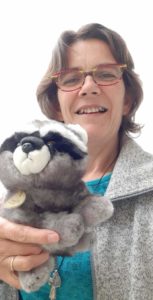 photo de Françoise de La Roche portant une peluche raton-laveur, mascotte de la promotion de formation Touch For Health : racoon.